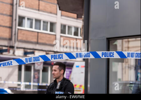 London, UK. 18. Juni 2015. Ein Polizist steht hinter der inneren Cordon Absperren Market Street, wie das Stadtzentrum von Watford zum Stillstand gebracht wird.  Straßen sind gesperrt, inmitten Berichte über ein verdächtiges Paket gefunden in der Market Street, die zur Detonation gebracht wurde, durch die Bombe Abfallbehälter sowie Berichte über eine Person in einer Burka, die heute verhaftet wurde, den ersten Tag der muslimischen fest des Ramadan. Bildnachweis: Stephen Chung / Alamy Live News Stockfoto