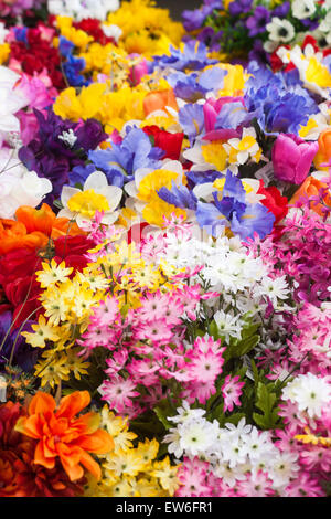 Kunstkunststoffblumen zum Verkauf am Marktstand in Dorchester, Dorset, Großbritannien im Juni Stockfoto