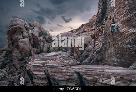 Ein Bergsteiger führt einen vertikalen Aufstieg bei Red Rocks, NV zu gekerbter Felsformationen. Stockfoto