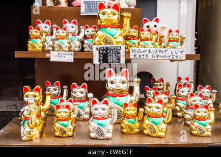 Japan, Kurashiki. Glücklicher Katzen-Shop, Anzeige außerhalb des Ladens von goldfarbenem Maneki, glücklichen Katzen, mit Armen, die dazu erhoben werden, Kunden im Laden zu belocken. Stockfoto