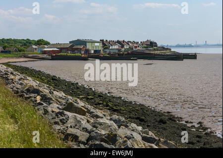 Blick über die Mudbanks der Mündung des Humber bei Ebbe auf einer stillgelegten Werft, verlassene Schiffe und das Dorf Paull Stockfoto