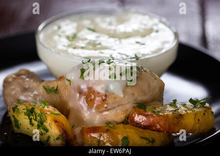 Gebackene Kartoffeln mit Brathähnchen Schlegel und Knoblauch-sauce Stockfoto