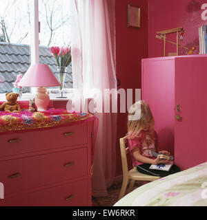 Kleine Mädchen spielen im Kinderzimmer rosa Stockfoto