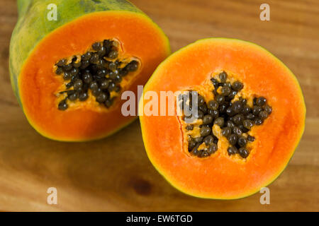 Papaya, Carica Papaya, mit Samen, halbieren auf Holz Hintergrund Stockfoto
