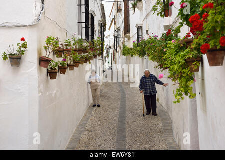 Älteres paar entlang weiß getünchten Mauern mit Geranie Blumentöpfe in Arcos De La Frontera Spanien Stockfoto