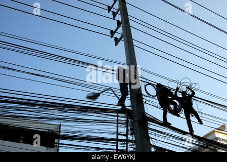 Elektrische Kabel-Monteure in einer gefährlichen Situation über einer Stadt Straße in Pattaya Thailand arbeiten Stockfoto