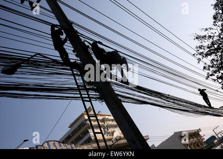 Elektrische Kabel-Monteure in einer gefährlichen Situation über einer Stadt Straße in Pattaya Thailand arbeiten Stockfoto