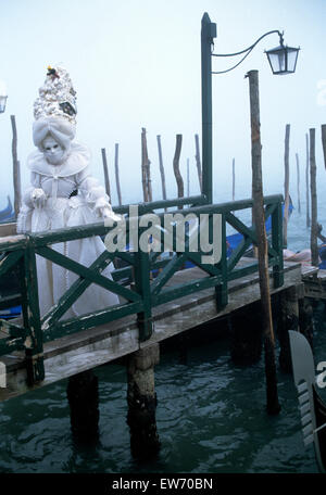 Ein einheimischer trug eine weiße traditionelle Maske und Roben, überqueren einer Brücke auf der Venedig Karneval für nur zur redaktionellen Nutzung Stockfoto