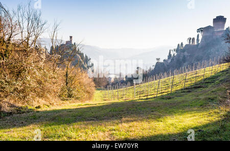 Die Backstein-Mauern einer mittelalterlichen Festung und mittelalterlichen Zinnen Uhrturm am Hügel in der Landschaft Stockfoto