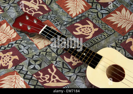 Eine Ukulele auf einem typischen hawaiianischen gemusterte Tuch positioniert. Stockfoto