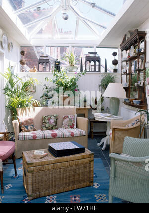 Ein traditionelles Wintergarten mit Korbmöbeln, Esstisch aus Glas