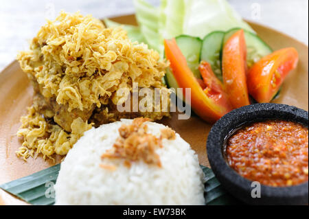 Brathähnchen Indonesisch-Stil, bekannt als Lalapan, serviert mit Reis, Sambal und Gemüse. Stockfoto