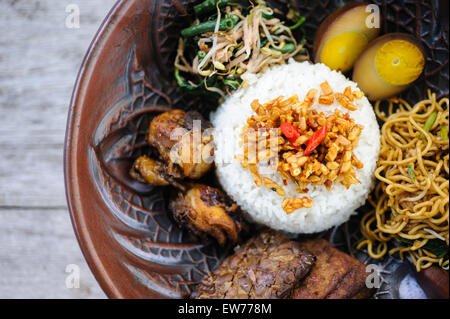 Indonesische Nasi Campur mit gebratenem Huhn, Nudeln, Eiern, Tempeh und Gemüse. Stockfoto