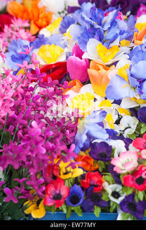 Kunstkunststoffblumen zum Verkauf am Marktstand in Dorchester, Dorset, Großbritannien im Juni Stockfoto