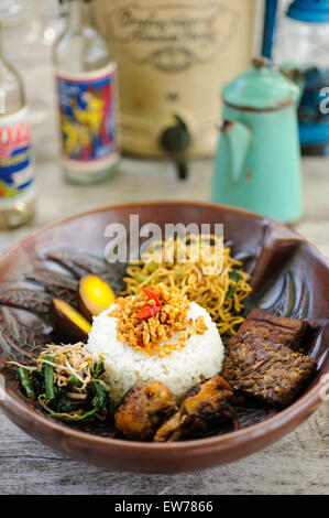 Indonesische Nasi Campur mit gebratenem Huhn, Nudeln, Eiern, Tempeh und Gemüse. Stockfoto