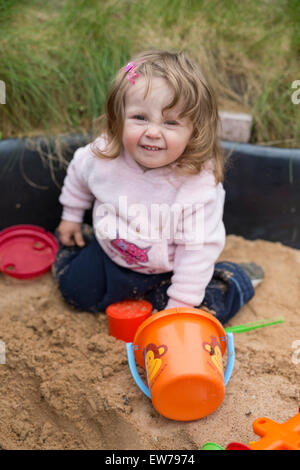 Kleine Mädchen spielen im Sandkasten Stockfoto