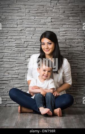 Mutter und Sohn sitzen auf dem Boden Stockfoto