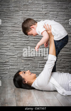 Mutter und Sohn auf dem Boden spielen Stockfoto
