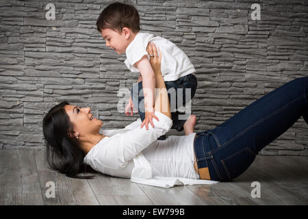 Mutter und Sohn auf dem Boden spielen Stockfoto