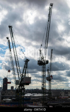 Silhouetten von Turmdrehkranen auf die Skyline arbeiten bei Bloomberg Place, London EG4 unter sammeln stürmisch, graue Wolken Stockfoto