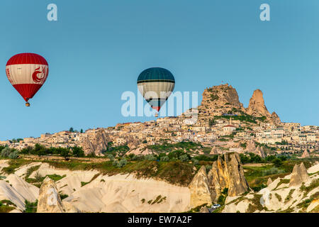 Heißluftballons mit Dorf von Ortahisar im Hintergrund, Kappadokien, Türkei Stockfoto