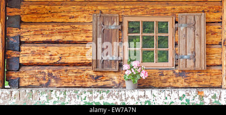 Fenster von einem alten Holzhaus mit Topfpflanze. Stockfoto