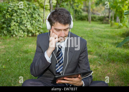 glücklich Kaufmann mit digital-Tablette und Kopfhörer, im freien Stockfoto