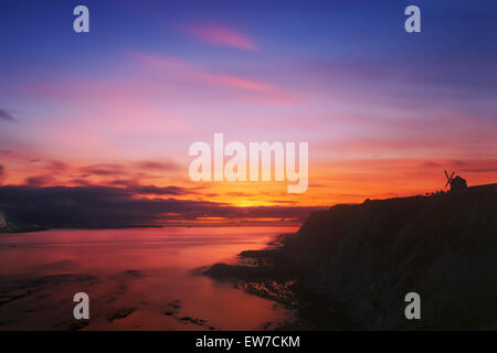 Sonnenuntergang in Getxo mit Aixerrota Mühle Silhouette und dramatische Roter Himmel Stockfoto