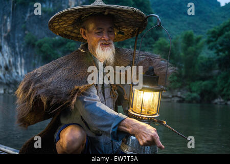 Porträt von einem alten chinesischen Fischer mit Laterne auf Bambus-Boot Stockfoto