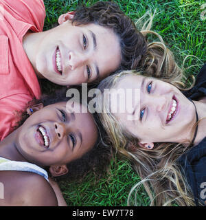 Erhöhten Blick auf drei lächelnden Kindern liegen auf dem Rasen Stockfoto