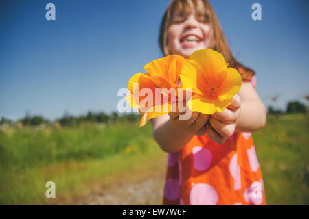 Mädchen mit einer Handvoll Orangenmohn, USA Stockfoto