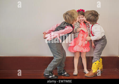 Zwei jungen, eine Mädchen auf die Wange küssen Stockfoto