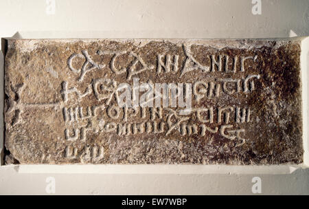 Grabstein von König Cadfan (Catamanus) von Gwynedd (d. AD625) inmitten einer Llangadwaladr Kirche, Anglesey auf seiner Seite (Kreuz oben). Stockfoto