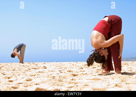 Mann und Frau auf einem Felsvorsprung am North Curl Curl, einer von Sydneys Nordstrände Yoga zu praktizieren. Sydney, N Stockfoto