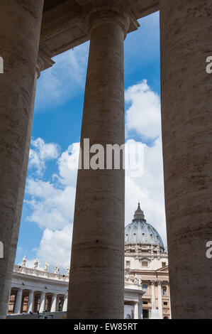 St Peter quadratische Berninis Kolonnade mit Dom St. Peter hinter Säulen im Hintergrund Stockfoto