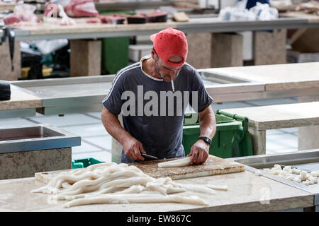 Menschen, die rauchen, während Schwarzer Degenfisch, die Reinigung ist ein Zooplanktons im Mercado Dos Lavradores, Fischmarkt in Funchal Madeira Stockfoto