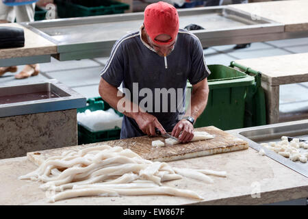 Menschen, die rauchen, während Schwarzer Degenfisch, die Reinigung ist ein Zooplanktons im Mercado Dos Lavradores, Fischmarkt in Funchal Madeira Stockfoto