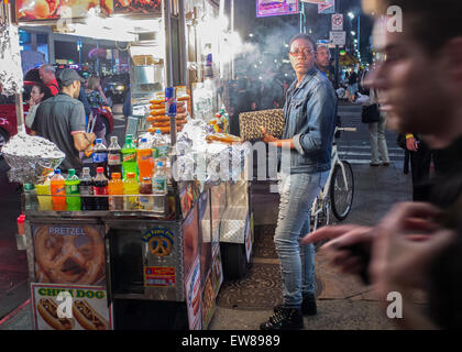 Frau hält eine Geldbörse Leopard an einen Hot Dog, Brezel Essen Warenkorb Anbieter außerhalb von New York Penn Station Stockfoto