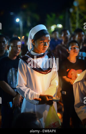 Nonne hält Kerze, wie sie mit anderen Gläubigen in einer Prozession der Semana Santa in Larantuka, Insel Flores, Indonesien marschiert. Stockfoto