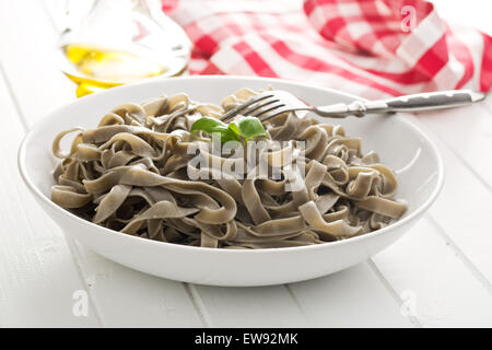 gekochte schwarze Tagliatelle Nudeln auf Teller Stockfoto