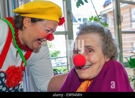 Schwerin, Deutschland. 5. Juni 2015. Krankenhaus-Clown "Kiki" (Kerstin Daum) lacht über die rote Nase die Annemarie Leonhardt während einer Führung durch den Pflege-Stationen des Pflegeheims "Augustenstift" in Schwerin, Deutschland, 5. Juni 2015 aufgesetzt hat. Die Clowns haben Demenzkranken und pflegebedürftigen einmal im Monat für die letzten zwei Jahre besucht. Foto: Jens Büttner/Dpa/Alamy Live News Stockfoto