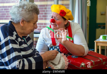 Schwerin, Deutschland. 5. Juni 2015. Krankenhaus-Clown "Kiki" (Kerstin Daum, R) singt ein traditionelles Volkslied für Edith Prueter während einer Führung durch den Pflege-Stationen des Pflegeheims "Augustenstift" in Schwerin, Deutschland, 5. Juni 2015. Die Clowns haben Demenzkranken und pflegebedürftigen einmal im Monat für die letzten zwei Jahre besucht. Foto: Jens Büttner/Dpa/Alamy Live News Stockfoto