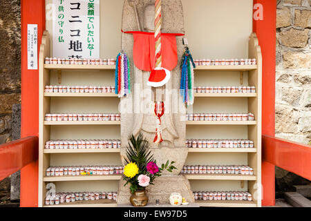 Große japanische Jizo, AKA Ojizo-sama, Jizo bosatsu, Statue mit Hunderten von kleinen hinter auf Racks am Senkoji Tempel, Onomichi, Japan. Stockfoto