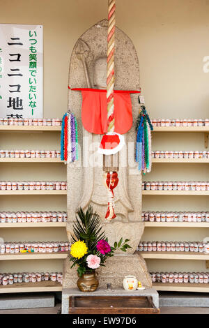 Große japanische Jizo, AKA Ojizo-sama, Jizo bosatsu, Statue mit Hunderten von kleinen hinter auf Racks am Senkoji Tempel, Onomichi, Japan. Stockfoto