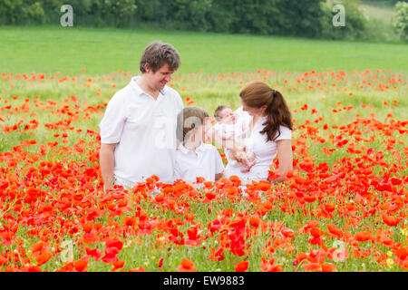 Schöne Familie vier stehen in einem wunderschönen Mohnblume-Feld Stockfoto