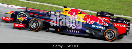 Dieses Bild zeigt, wie Sebastian Vettel während des Großen Preises von Malaysia 2013 Mark Webber überholt und den intensiven Rennmoment zeigt. Vettels Manöver verdeutlichen sein Können und den Wettkampfcharakter des Formel-1-Rennens. Stockfoto