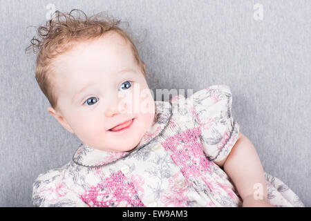 Wunderschönes kleines Mädchen in einem geblümten Kleid Stockfoto