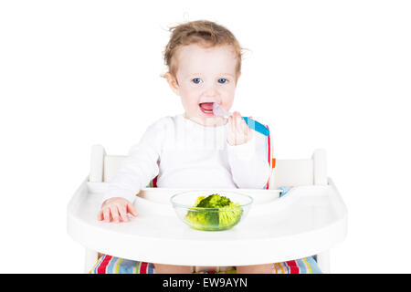 Süße kleine Baby Essen Brokkoli, isoliert auf weiss Stockfoto