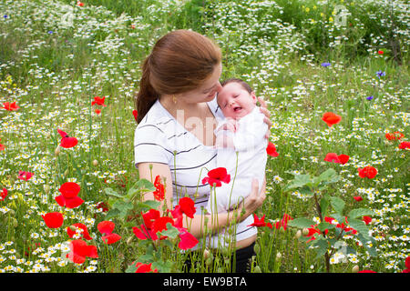 Mutter und ihr neugeborenes Baby in eine schöne Blumenfeld Stockfoto