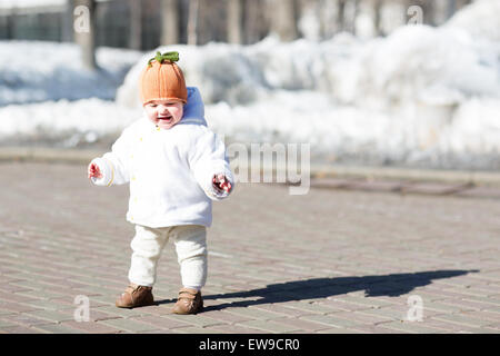Kleines Baby, die ihre ersten Schritte an einem sonnigen Frühlingstag Stockfoto
